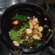 Step five: Make a garlic tempering. Add oil in a small pan. Add chopped garlic, mustard seeds, white lentils, curry leaves, and broken red chilies. Saute till mustard seeds pop. By this time, lentils and garlic also turn golden brown.