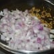 Step two: Heat oil in a deep-bottomed pan. Add cumin seeds. Let them sizzle. Add chopped onions. Saute till they turn transparent and pinkish.
