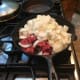 Adding together the onions and the meat.
