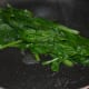 Step one: Saute the spinach leaves until they wilt. Hold them tight and chop into 1-inch pieces.