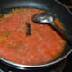 Step seven: Add tomato puree. Stir-cook till the water evaporates from the mix.