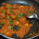 Step eleven: Add koftas. I added koftas, keeping a few for myself to eat as snacks. Mix well. Stir-cook the mix for a minute. Turn off the stove. Garnish the curry with chopped coriander leaves.