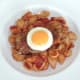 Fried egg circle is laid on pork steak