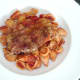 Paprika spiced pork steak is laid on conchiglie pasta