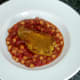 Turmeric spiced pork steak is laid on chickpeas