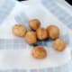 Deep fried potatoes are drained on kitchen paper