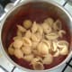 Conchiglie pasta is added to tomato sauce