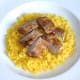 Sliced pork steak is arranged on turmeric rice