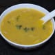 Step seven: Pour the hot soup equally into 4 bowls. Add 1/4 tsp butter and some grated paneer. Garnish with a few chopped fresh basil. Serve it!