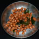Roast peanuts in a deep-bottomed pan. Transfer them to a plate to keep aside.