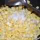Step five: Add salt. Mix well. Stir-cook for 3-4 minutes. Now the sweet corn changes into a darker shade. Turn off the stove.
