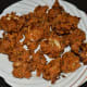 Step six: Transfer the cooked pakoras to a plate lined with an absorbent paper.