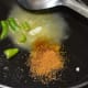 Step two: Drop some butter into a heated deep-bottomed pan. Add chopped chilies and garam masala powder. Saute for 15 seconds.