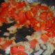 After a few minutes, add your roughly chopped tomato and allow it to cook with the onion and garlic until it starts to turn soft.