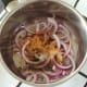 Sliced onion and spices are added to saucepan
