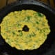 Step 6: Heat a griddle or flat pan and apply some oil. Place the pancake on it and add a few drops of oil on the top and the edges. Gently press it with a spatula. Cover the pan for 1–2 minutes while keeping the heat on medium-low.