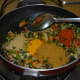 Step seven: Add all the spice powders one by one. Reduce the heat. Add sugar and remaining salt. Mix well.