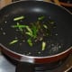 Heat oil in a wok or deep-bottomed pan and throw in the mustard seeds. Sauté until they crackle. Add the slit green chilies, hing powder, and curry leaves. Sauté for 30 seconds.