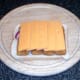 Cheese is laid over fish fingers and onion