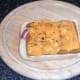 Ground pepper is scattered over melted cheese
