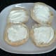 Cream cheese spread on halved bread rolls