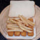 Chips are placed on top of fish fingers
