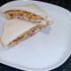 Cheese and onion fish finger sandwich is arranged on serving plate