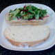 Salad leaves are laid on thick slice of bread