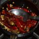 Step two: Fry white lentils, coriander seeds, and dry red chilies in some oil.