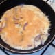 Cheese is grated over partly set omelette