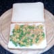 Peas are spread on bottom slice of bread