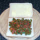 Spicy beans are spread on first slice of bread