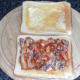 Sardines in tomato sauce are spread on toast