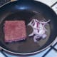 Onion is added to pan with turned sausage