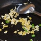 Step five: Now, start making the gravy. Heat oil in a pan. Throw in chopped ginger, garlic, and green chilies. Saute them for a minute.