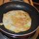 Flip it when the bottom gets golden. Add a few drops of ghee or oil on the surface. No need to cover the pan. Remove it once the other side also gets golden-brown.