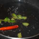 Step three: Heat a tablespoon of oil in a deep-bottomed pan. Throw in mustard seeds. Let them crackle. Add dry red chili and curry leaves. Saute for a while.