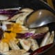 Step four: Add eggplant slices. Throw in some salt. Add turmeric powder. Mix well.