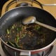 Step one: Heat oil in a pan. Throw in mustard seeds. Let them crackle. Add white lentils, curry leaves, and slit green chilies. Saute till lentils become golden brown.