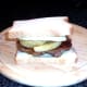 Top is placed on steak, egg and chips sandwich