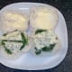 Blue cheese slices are laid on salad leaves