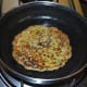 When the bottom side becomes golden brown, flip the pancake. Add a few drops of oil on the topside. No need to cover the pan.