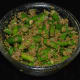 Step six: Add the spice powder to the bowl containing bite-sized green chilies. Add mustard oil, vinegar, and salt. Mix well. Your favorite green chili pickle is ready.