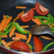 Step two: Add salt to taste. Throw in quartered tomatoes. Continue sauteing.