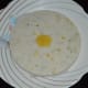 Step six: Pour this batter up to 1/2 inch think in the greased tatte idli plate or cooker container. Steam-cook for 18-20 minutes. Take them out, run a blunt knife around the edge. Put the idli plate up side down on a serving plate.