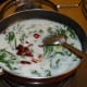 Step six: Add coconut milk to the pan. Throw in red chili flakes. Let the heat be medium high.