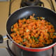 Step four: By this time, the carrot mixture should be almost dry. Throw in grated coconut. Add remaining salt. Mix well. Turn off the stove.