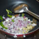Step two: Heat oil in a deep-bottomed pan. Throw in cumin seeds. Let them sizzle. Add chopped onions, ginger, and slit green chilies.