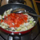 Step four: Add chopped tomatoes. Continue stir-cooking till tomatoes become mushy.