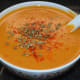 Step nine: Divide between four bowls. Garnish with red chili powder and dried oregano flakes. Enjoy sipping this hot, spicy, and creamy soup on a winter day!
